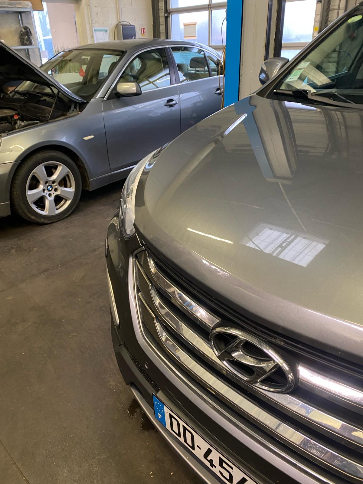 Le même capot de SUV gris après débosselage, la ligne de tôle est redevenue nette
